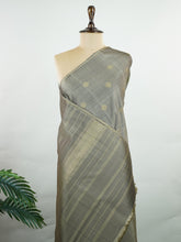 Kanchipuram Silk Soft grey silk enriched with intricate kolam buttas in pure zari. The muted tones radiate understated elegance for refined gatherings. Lightweight yet luxurious in drape. A subtle masterpiece for quiet sophistication. #GreySilkSaree #KolamButta #PureZariKanjivaram #MinimalLuxury Hemavati - Manoranjitham Weaves - Handloom Store