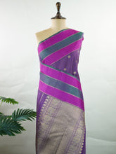 Kanchipuram Silk Experience the elegance of this pure Zari Oosi Kattam saree from Kanchipuram, featuring intricate gold and silver threads woven into a rich purple fabric. The vibrant multi-gap borders in pink and green add a striking contrast, perfect for festive occasions. This masterpiece combines comfort and artistry, making it a timeless choice for celebrations. Padma - Manoranjitham Weaves - Handloom Store