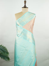Kanchipuram Silk A delicate peach Kanchipuram silk saree woven with gold zari buttas, reflecting quiet sophistication. The cyan border adds a refreshing vibrance, creating a unique interplay of colours. Crafted from 100% pure silk, this saree is a testament to timeless handloom artistry. Perfect for bridal trousseaus and festive celebrations. #ManoranjithamSilks #KanjivaramHandloom #PureSilkSaree #BridalElegance #TimelessTradition Surutia - Manoranjitham Weaves - Handloom Store