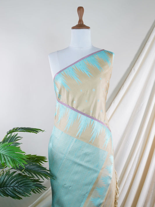 Gadwal Silk This Gadwal silk saree, adorned in Beige and detailed with Pure Zari weaving, reflects the grandeur of Gadwal. The timeless Buttis motifs enhance its bridal charm. A perfect blend of luxury and tradition, it is designed for those who appreciate fine craftsmanship. Ritigowla - Manoranjitham Weaves - Handloom Store