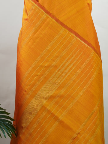 Kanchipuram Silk A bold classic in 100% pure silk, this Kanchipuram weave is a celebration of grace in its plain, glowing form. The vibrant body, paired with subtle gold zari, creates a quiet sophistication without the need for borders. Handwoven with devotion, it honours the legacy of bridal silks with contemporary elegance. An heirloom-worthy drape from Manoranjitham’s borderless Kanjivaram series. #KanchipuramSilk #Manoranjitham #PureZari #HandloomLuxury #TimelessElegance Padmakshi - Manoranjitham Weaves