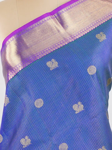 Kanchipuram Silk In a striking combination of blue and purple, this Vairavoosi Kanchipuram saree in 100% pure silk is woven with pure zari and finished with a medium border. Bold yet elegant, this drape mirrors the rhythm of traditional craft. A regal weave for those who carry confidence in colour. #Manoranjitham #VairavoosiWeave #KanjivaramSilks #HandloomStory #BoldAndTraditional Sreemaata - Pure Kanjivaram Silk Saree | Vairavoosi Weave - Manoranjitham Weaves - Handloom Store