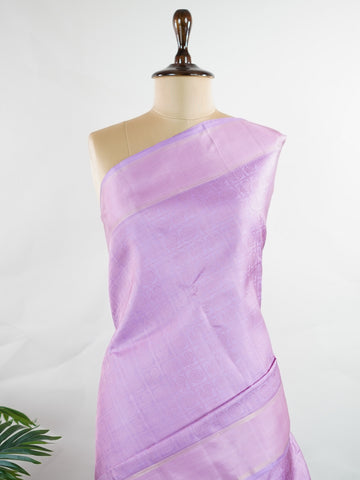 Kanchipuram Silk A rare lavender silk drape, adorned with traditional kattam checks and delicate buttas. The silver-gold zari glistens, casting a regal glow on this soft pastel beauty. Perfect for evening weddings where elegance speaks in hushed tones. An heirloom piece, woven with precision in the looms of Kanchipuram. #LavenderKanjivaram #KattamChecks #PureZari #HeritageSilks Shubhapantuvarali - Lavender Pure Kanjivaram Silk Saree | Woven Buttas - Manoranjitham Weaves - Handloom Store