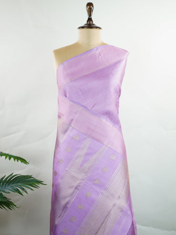 Kanchipuram Silk A rare lavender silk drape, adorned with traditional kattam checks and delicate buttas. The silver-gold zari glistens, casting a regal glow on this soft pastel beauty. Perfect for evening weddings where elegance speaks in hushed tones. An heirloom piece, woven with precision in the looms of Kanchipuram. #LavenderKanjivaram #KattamChecks #PureZari #HeritageSilks Shubhapantuvarali - Lavender Pure Kanjivaram Silk Saree | Woven Buttas - Manoranjitham Weaves - Handloom Store
