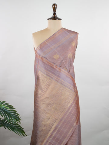 Kanchipuram Silk Earthy elegance meets intricate artistry in this light brown Kanjivaram. Oosikattam patterns and tiny buttas add texture to the soft sheen of silk. Ideal for cultural events and sacred celebrations. A classic drape for women who value understated heritage. #LightBrownSilk #OosikattamWeave #PureZari #HandloomBeauty Kedaragaula - Manoranjitham Weaves - Handloom Store