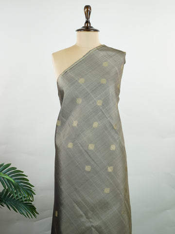 Kanchipuram Silk Soft grey silk enriched with intricate kolam buttas in pure zari. The muted tones radiate understated elegance for refined gatherings. Lightweight yet luxurious in drape. A subtle masterpiece for quiet sophistication. #GreySilkSaree #KolamButta #PureZariKanjivaram #MinimalLuxury Hemavati - Manoranjitham Weaves - Handloom Store