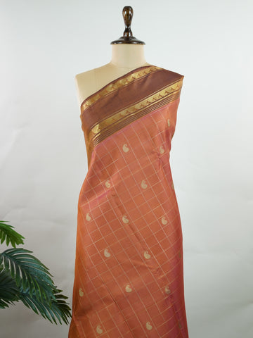 Kanchipuram Silk Peach and brown blend beautifully in this kattam-check Kanjivaram. Zari glints across each square, framing the body in heritage charm. Perfect for day-to-evening transitions. A saree that celebrates classic handloom artistry. #PeachBrownSaree #KattamChecks #PureZari #TimelessWeaves Vachaspati - Manoranjitham Weaves - Handloom Store