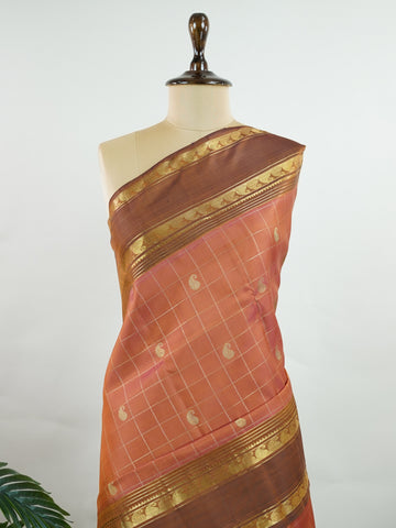 Kanchipuram Silk Peach and brown blend beautifully in this kattam-check Kanjivaram. Zari glints across each square, framing the body in heritage charm. Perfect for day-to-evening transitions. A saree that celebrates classic handloom artistry. #PeachBrownSaree #KattamChecks #PureZari #TimelessWeaves Vachaspati - Manoranjitham Weaves - Handloom Store