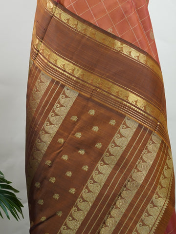 Kanchipuram Silk Peach and brown blend beautifully in this kattam-check Kanjivaram. Zari glints across each square, framing the body in heritage charm. Perfect for day-to-evening transitions. A saree that celebrates classic handloom artistry. #PeachBrownSaree #KattamChecks #PureZari #TimelessWeaves Vachaspati - Manoranjitham Weaves - Handloom Store