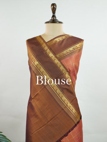 Kanchipuram Silk Peach and brown blend beautifully in this kattam-check Kanjivaram. Zari glints across each square, framing the body in heritage charm. Perfect for day-to-evening transitions. A saree that celebrates classic handloom artistry. #PeachBrownSaree #KattamChecks #PureZari #TimelessWeaves Vachaspati - Manoranjitham Weaves - Handloom Store