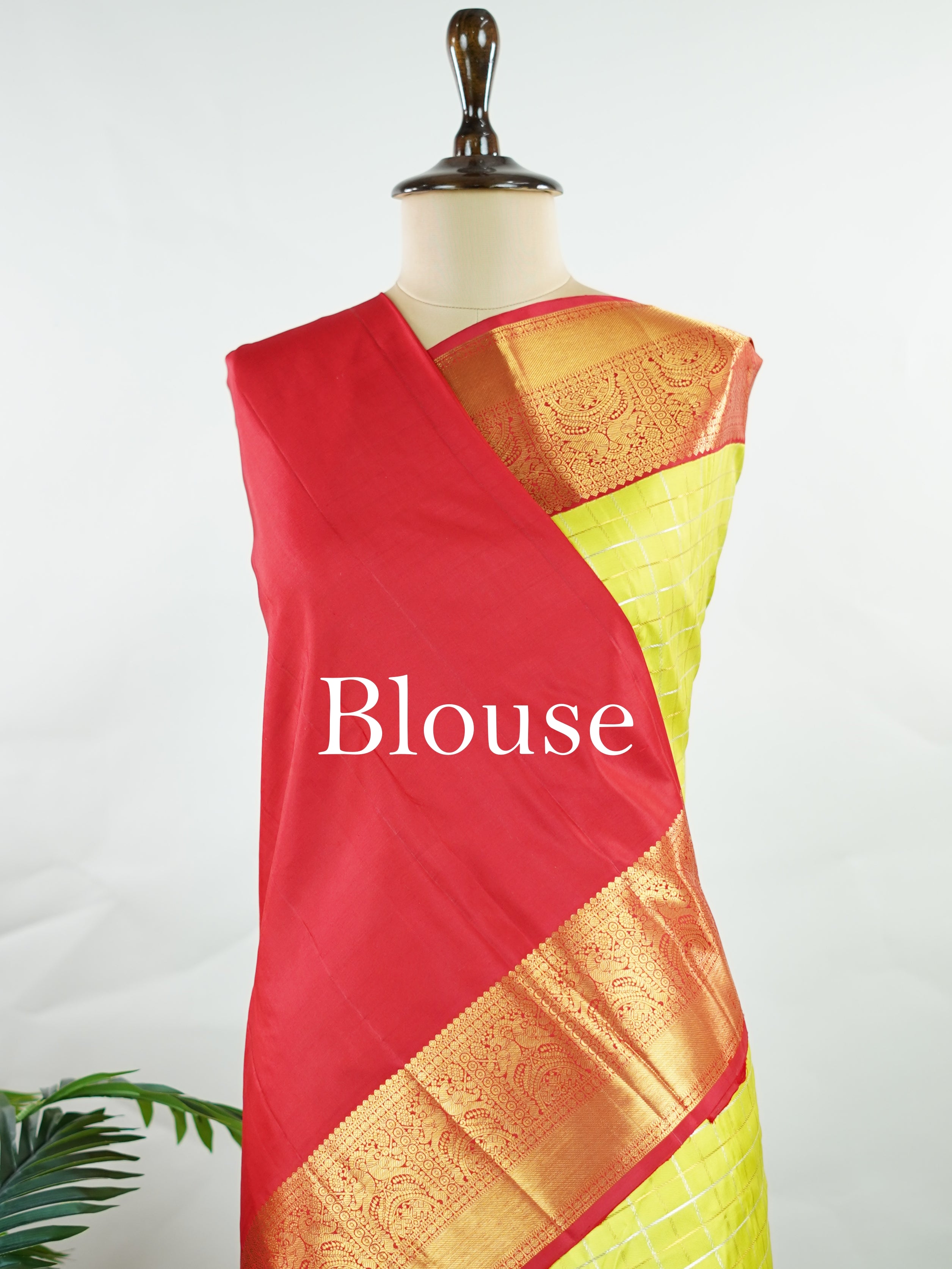 Kanchipuram Silk Beautiful traditional Kanjivaram saree featuring a vibrant Leaf Green body adorned with exquisite gold and silver checks, creating a rich and radiant appearance. The striking Red border is embellished with majestic Annapakshi motifs, adding a touch of heritage and timeless elegance. An intricately woven pallu with classic diamond motifs enhances the grandeur and sophistication of the drape. Paired with a plain Red blouse, this masterpiece is perfect for weddings, festive occasions, and trad