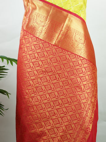 Kanchipuram Silk Beautiful traditional Kanjivaram saree featuring a vibrant Leaf Green body adorned with exquisite gold and silver checks, creating a rich and radiant appearance. The striking Red border is embellished with majestic Annapakshi motifs, adding a touch of heritage and timeless elegance. An intricately woven pallu with classic diamond motifs enhances the grandeur and sophistication of the drape. Paired with a plain Red blouse, this masterpiece is perfect for weddings, festive occasions, and trad
