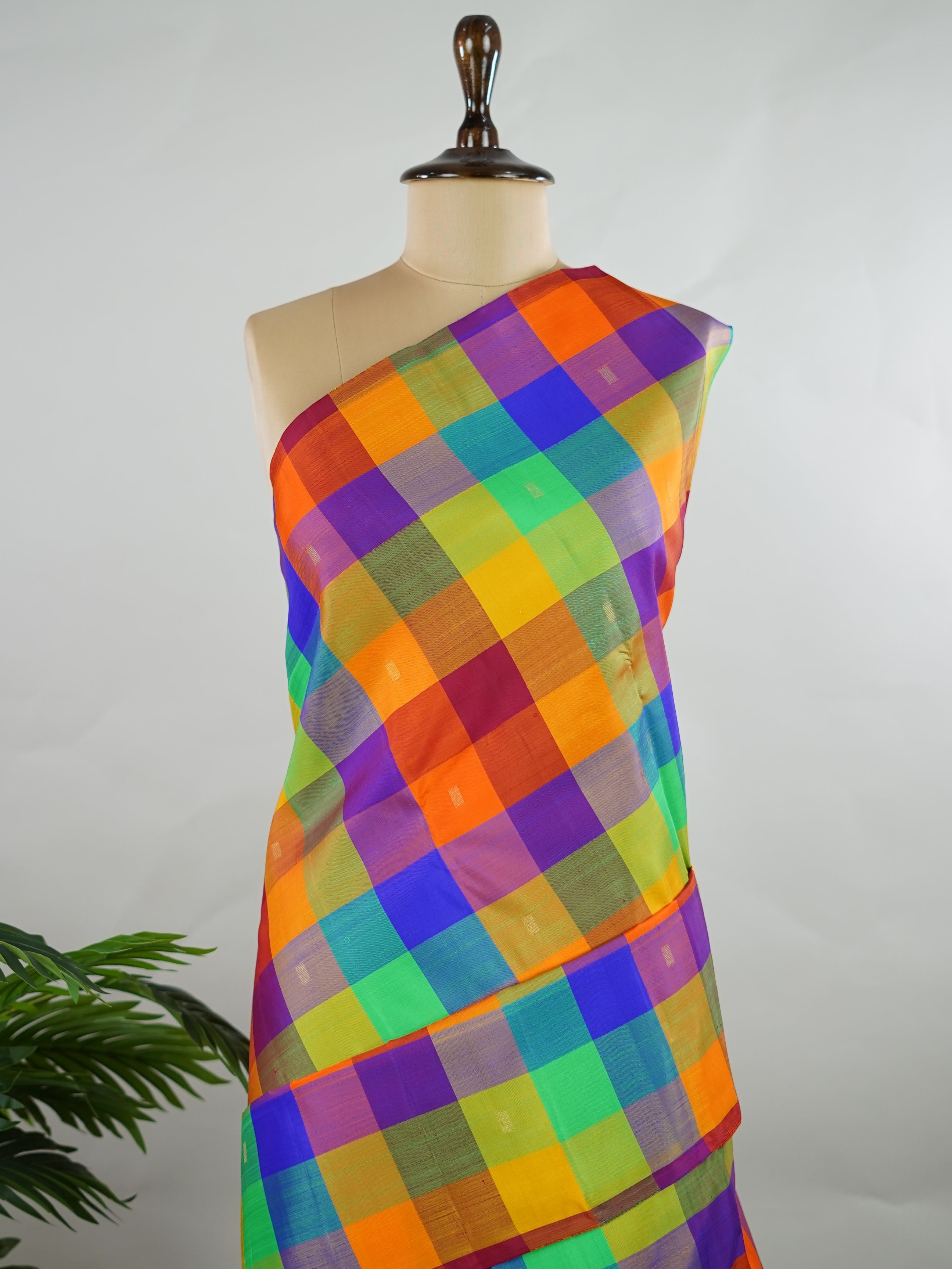 Kanchipuram Silk Borderless handloom Kanjivaram with multicolour checks and delicate buttis throughout.br
Complemented by a rich maroon pallu and blouse in pure zari, giving it a timeless vintage elegance. Kamakalatmika - Multicolour Pure Kanjivaram Silk Saree | Woven Buttas - Manoranjitham Weaves - Handloom Store