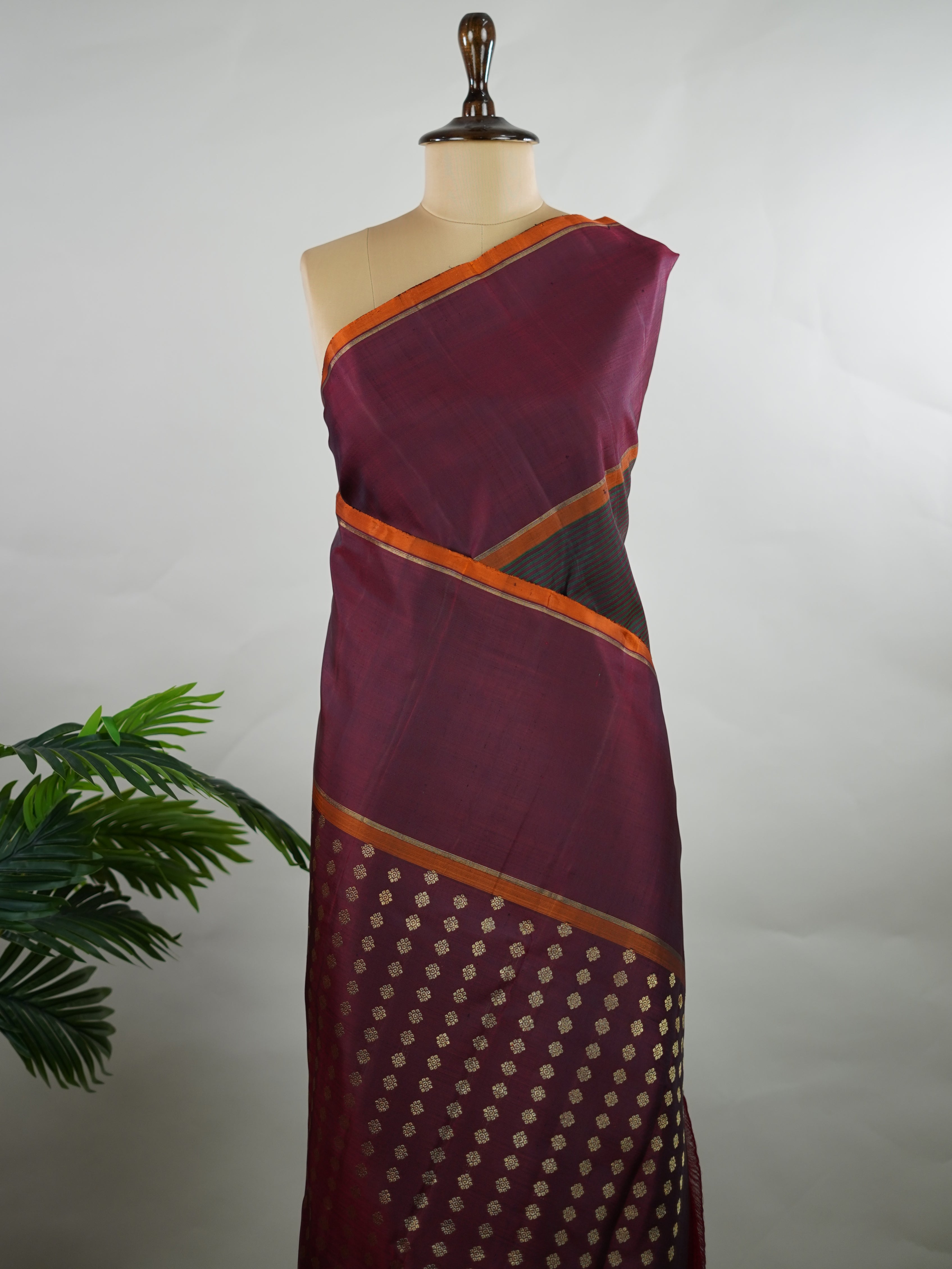 Kanchipuram Silk Green and maroon multi-stripe handloom Kanjivaram, with dancing peacock motifs above the border and a clean big-gap border design.
The maroon pallu features the classic laksha butti concept, giving it a vintage, timeless charm. Manonmani - Manoranjitham Weaves - Handloom Store