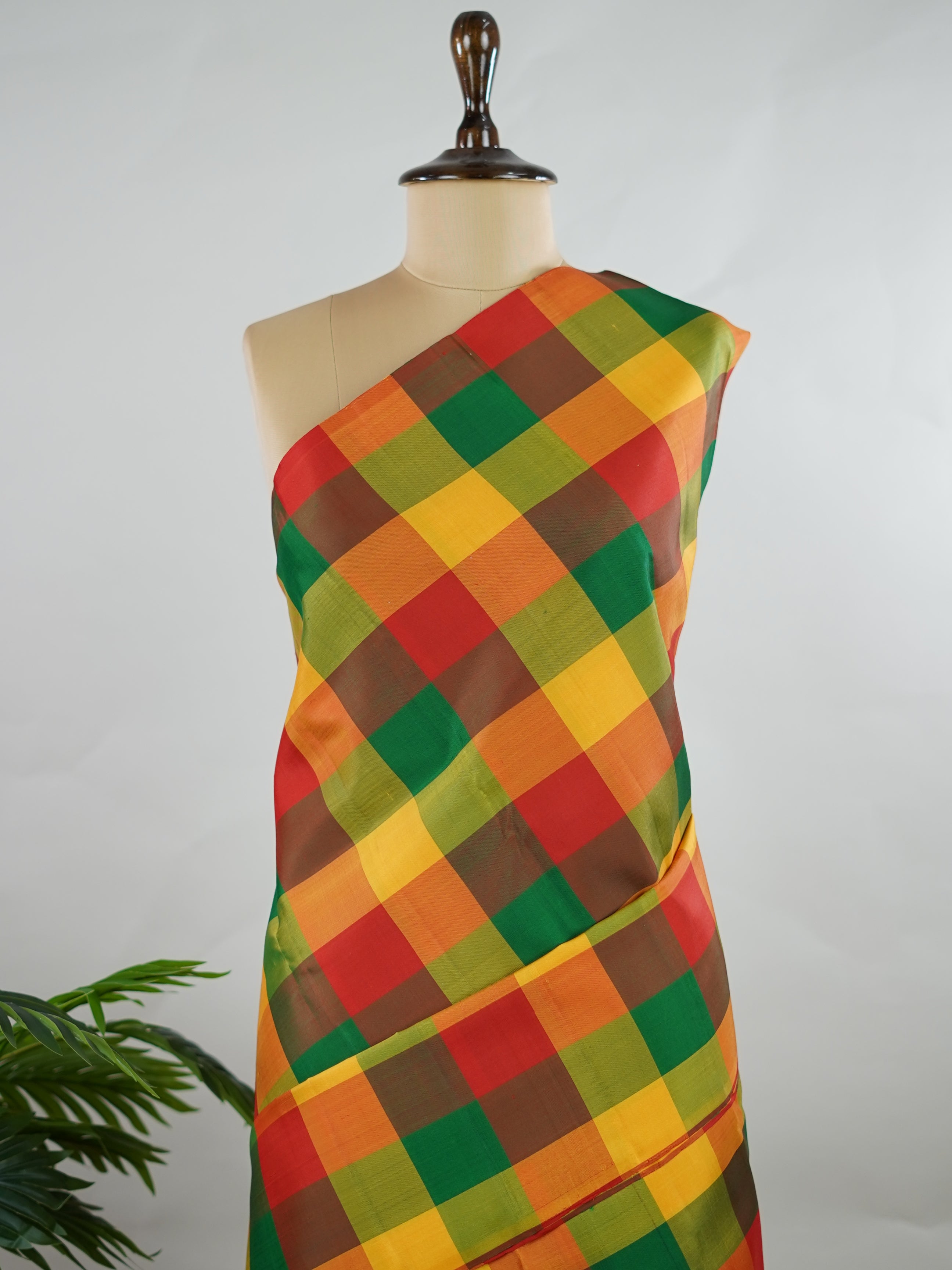 Kanchipuram Silk Borderless handloom Kanjivaram with multi-coloured checks, simple and elegant.
Complemented by a rich red pallu and blouse, perfect for a classic, timeless look. Hamsa Vahini - Manoranjitham Weaves - Handloom Store