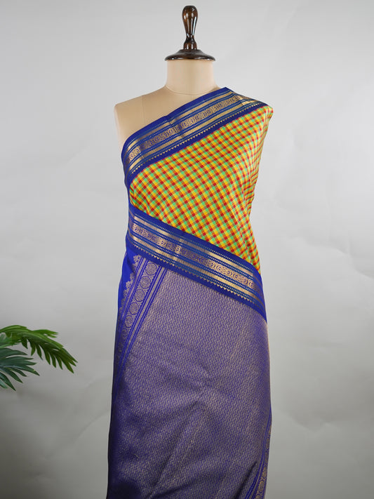 Kanchipuram Silk Pure silk woven with fine multi small checks.
Accented with a traditional blue korvai (kuttu) border.
Finished with a blue pallu and matching blouse for timeless elegance. Shyama - Manoranjitham Weaves - Handloom Store