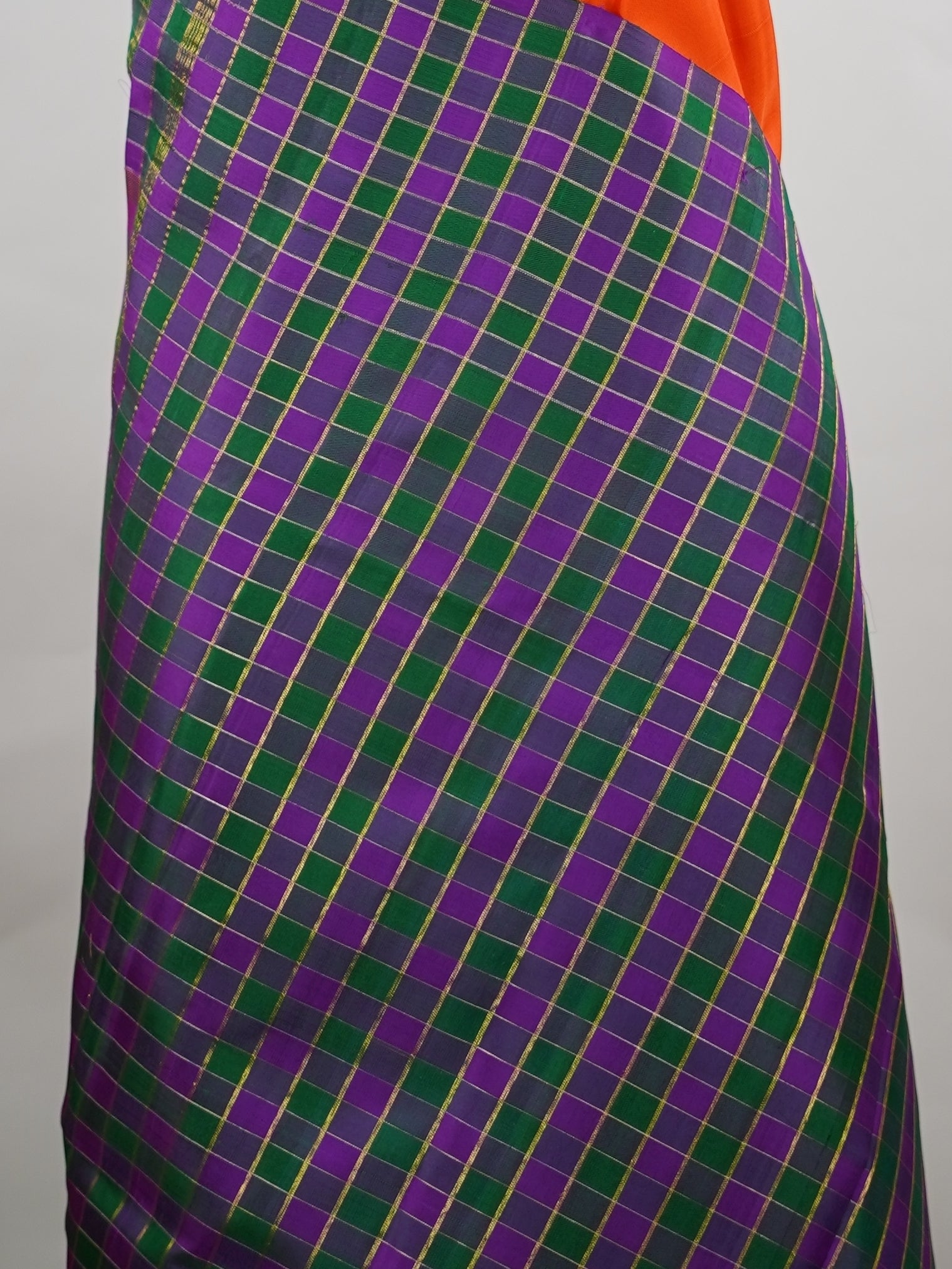 Kanchipuram Silk Pure silk in vibrant orange.
Paired with temple borders and multi-colour checked borders.
Blouse and pallu echo the same border design for a harmonious, elegant look. Kamini - Manoranjitham Weaves - Handloom Store