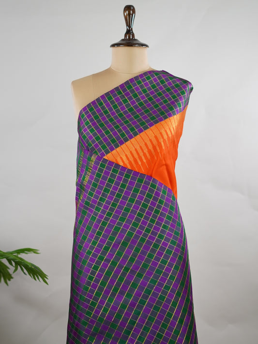 Kanchipuram Silk Pure silk in vibrant orange.
Paired with temple borders and multi-colour checked borders.
Blouse and pallu echo the same border design for a harmonious, elegant look. Kamini - Manoranjitham Weaves - Handloom Store