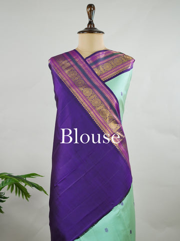Kanchipuram Silk Pure silk in sea green with delicate resham motifs on the body.
Paired with a rich purple border and pallu.
A harmonious blend of colour and craftsmanship for timeless elegance. Viseshini - Manoranjitham Weaves - Handloom Store
