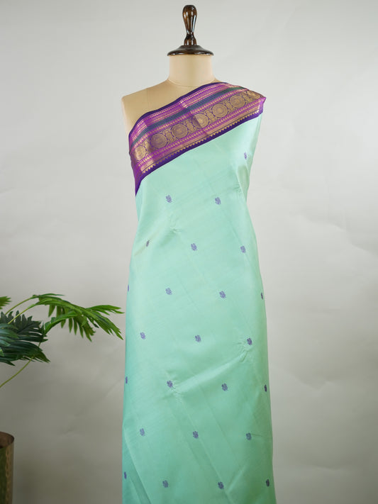 Kanchipuram Silk Pure silk in sea green with delicate resham motifs on the body.
Paired with a rich purple border and pallu.
A harmonious blend of colour and craftsmanship for timeless elegance. Viseshini - Manoranjitham Weaves - Handloom Store