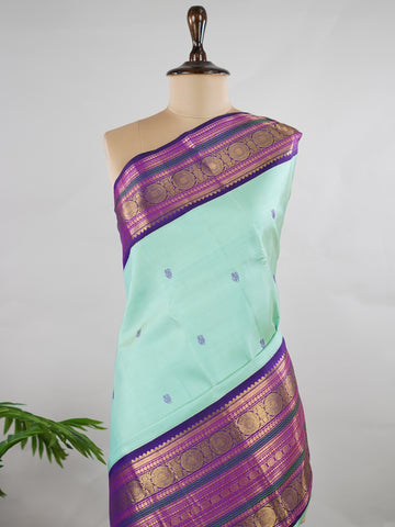 Kanchipuram Silk Pure silk in sea green with delicate resham motifs on the body.
Paired with a rich purple border and pallu.
A harmonious blend of colour and craftsmanship for timeless elegance. Viseshini - Manoranjitham Weaves - Handloom Store