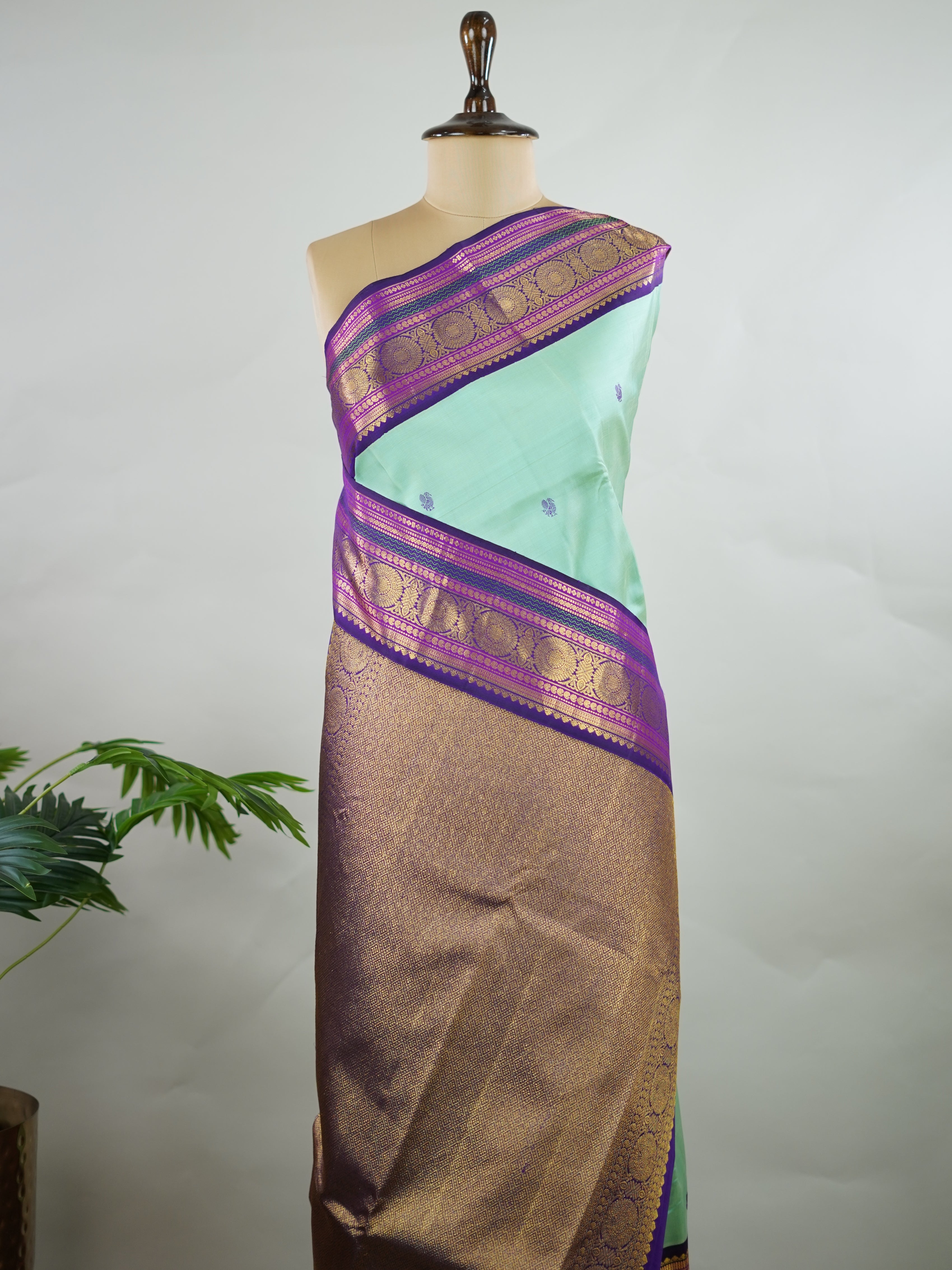 Kanchipuram Silk Pure silk in sea green with delicate resham motifs on the body.
Paired with a rich purple border and pallu.
A harmonious blend of colour and craftsmanship for timeless elegance. Viseshini - Manoranjitham Weaves - Handloom Store