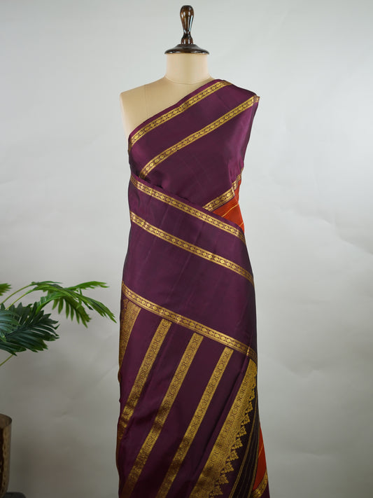 Kanchipuram Silk Pure silk in rust orange with bold horizontal stripes.
Paired with big purple gap borders.
A striking combination of colour and traditional craftsmanship. Kamini - Manoranjitham Weaves - Handloom Store