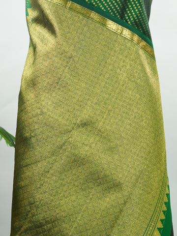 Kanchipuram Silk Crafted in luxurious 100% pure silk, this elegant green Kanjivaram saree is a timeless classic. The body is adorned with delicate small buttis that add subtle charm and richness to the weave. Perfect for weddings, festive occasions, and special celebrations, it drapes beautifully with a regal yet graceful appeal. Shivapriya - Green Pure Kanjivaram Silk Saree - Manoranjitham Weaves - Handloom Store