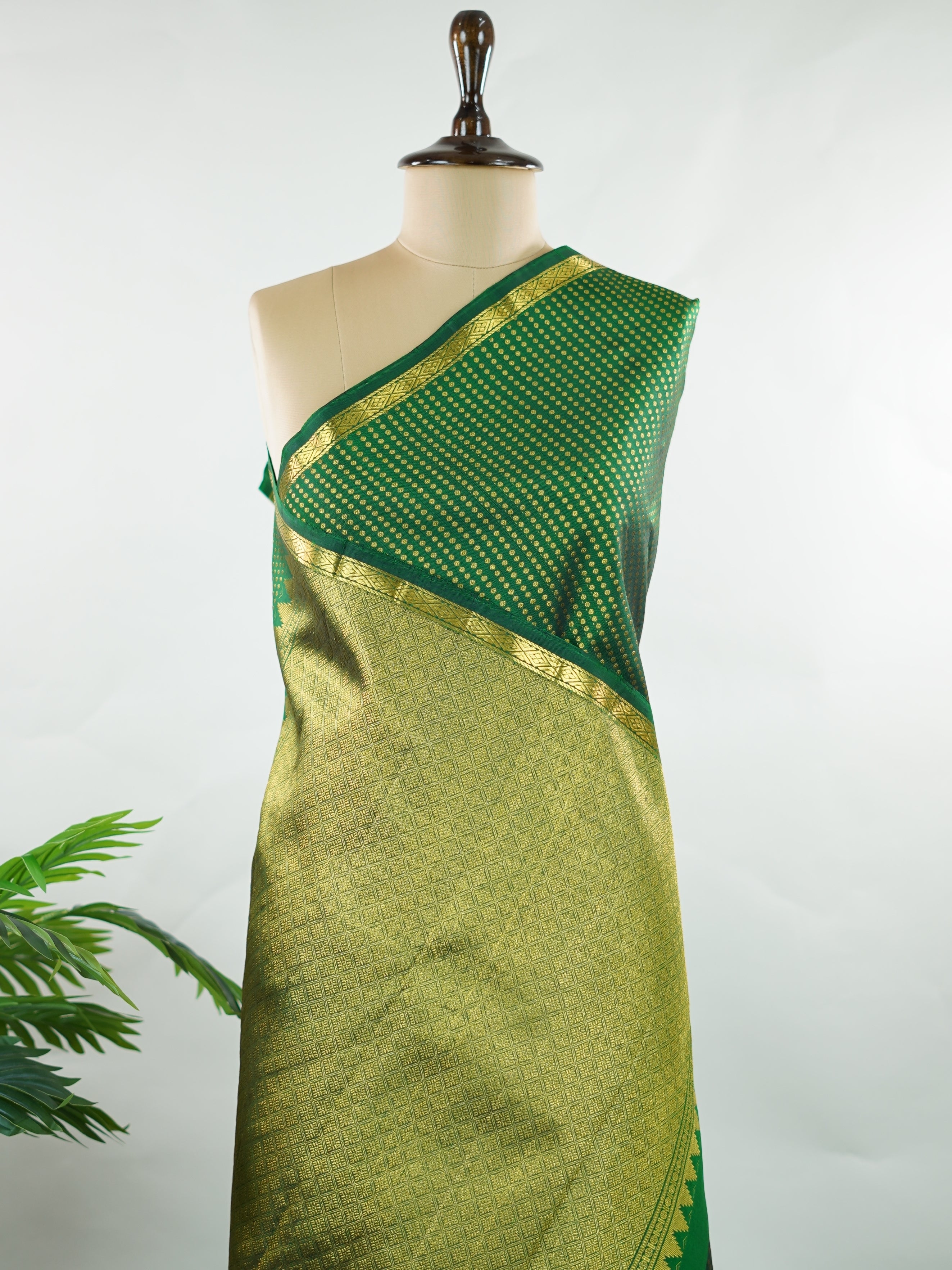 Kanchipuram Silk Crafted in luxurious 100% pure silk, this elegant green Kanjivaram saree is a timeless classic. The body is adorned with delicate small buttis that add subtle charm and richness to the weave. Perfect for weddings, festive occasions, and special celebrations, it drapes beautifully with a regal yet graceful appeal. Shivapriya - Green Pure Kanjivaram Silk Saree - Manoranjitham Weaves - Handloom Store