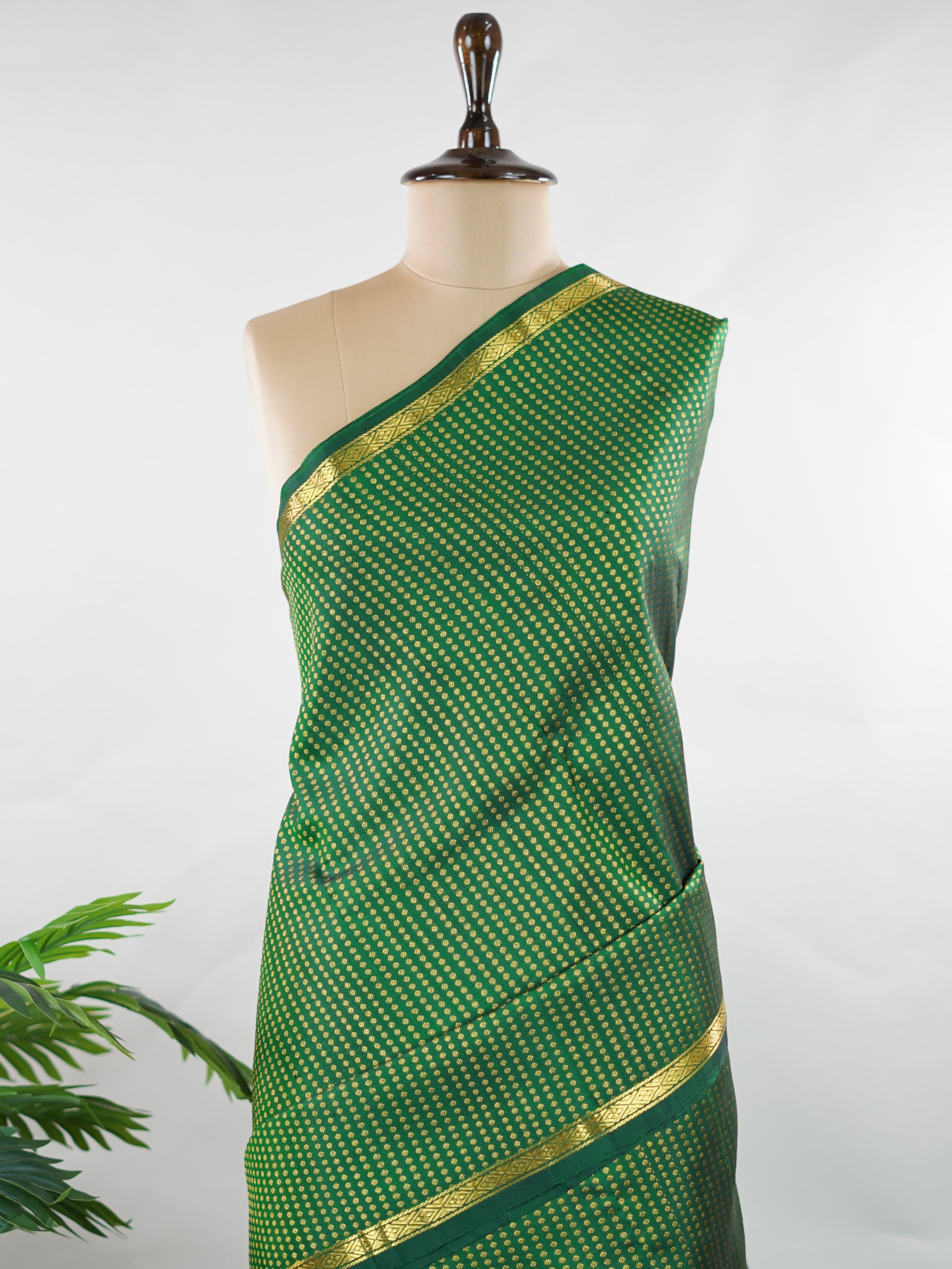 Kanchipuram Silk Crafted in luxurious 100% pure silk, this elegant green Kanjivaram saree is a timeless classic. The body is adorned with delicate small buttis that add subtle charm and richness to the weave. Perfect for weddings, festive occasions, and special celebrations, it drapes beautifully with a regal yet graceful appeal. Shivapriya - Green Pure Kanjivaram Silk Saree - Manoranjitham Weaves - Handloom Store