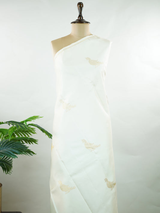 Kanchipuram Silk Elegant and refreshing, this white and yellow Kanjivaram saree is woven in luxurious 100% pure silk for a rich, graceful drape. The body features charming parrot motifs that stand out beautifully against the soft contrast tones. Designed without a traditional border, it offers a modern, seamless look while retaining the timeless grandeur of classic Kanjivaram craftsmanship. Tripurasundari - Manoranjitham Weaves - Handloom Store