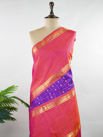 Kanchipuram Silk Elegant and striking, this violet Kanjivaram saree is woven in luxurious 100% pure silk for a rich, graceful drape. The body is adorned with delicate buttis, while the contrasting pinkish orange gap border adds a bold and contemporary touch. A perfect fusion of classic tradition and statement design—ideal for weddings and festive celebrations Mahamaya - Violet Pure Kanjivaram Silk Saree - Manoranjitham Weaves - Handloom Store