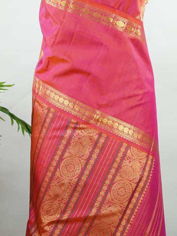 Kanchipuram Silk Elegant and striking, this violet Kanjivaram saree is woven in luxurious 100% pure silk for a rich, graceful drape. The body is adorned with delicate buttis, while the contrasting pinkish orange gap border adds a bold and contemporary touch. A perfect fusion of classic tradition and statement design—ideal for weddings and festive celebrations Mahamaya - Violet Pure Kanjivaram Silk Saree - Manoranjitham Weaves - Handloom Store