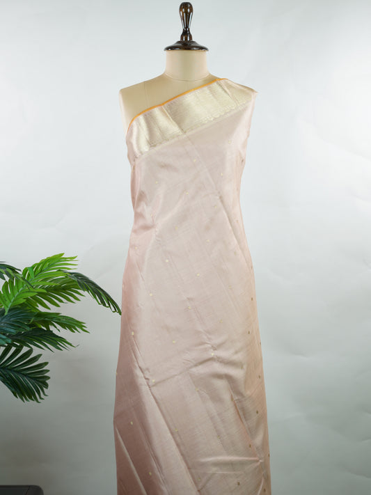 Kanchipuram Silk Understated and elegant, this cream Kanjivaram saree is woven in luxurious 100% pure silk for a soft, graceful drape. Featuring classic Vairavoosi weaving complemented by delicate buttis across the body, it reflects timeless craftsmanship with subtle richness. A refined choice for weddings, traditional gatherings, and serene festive moments. Anandalahari - Manoranjitham Weaves - Handloom Store