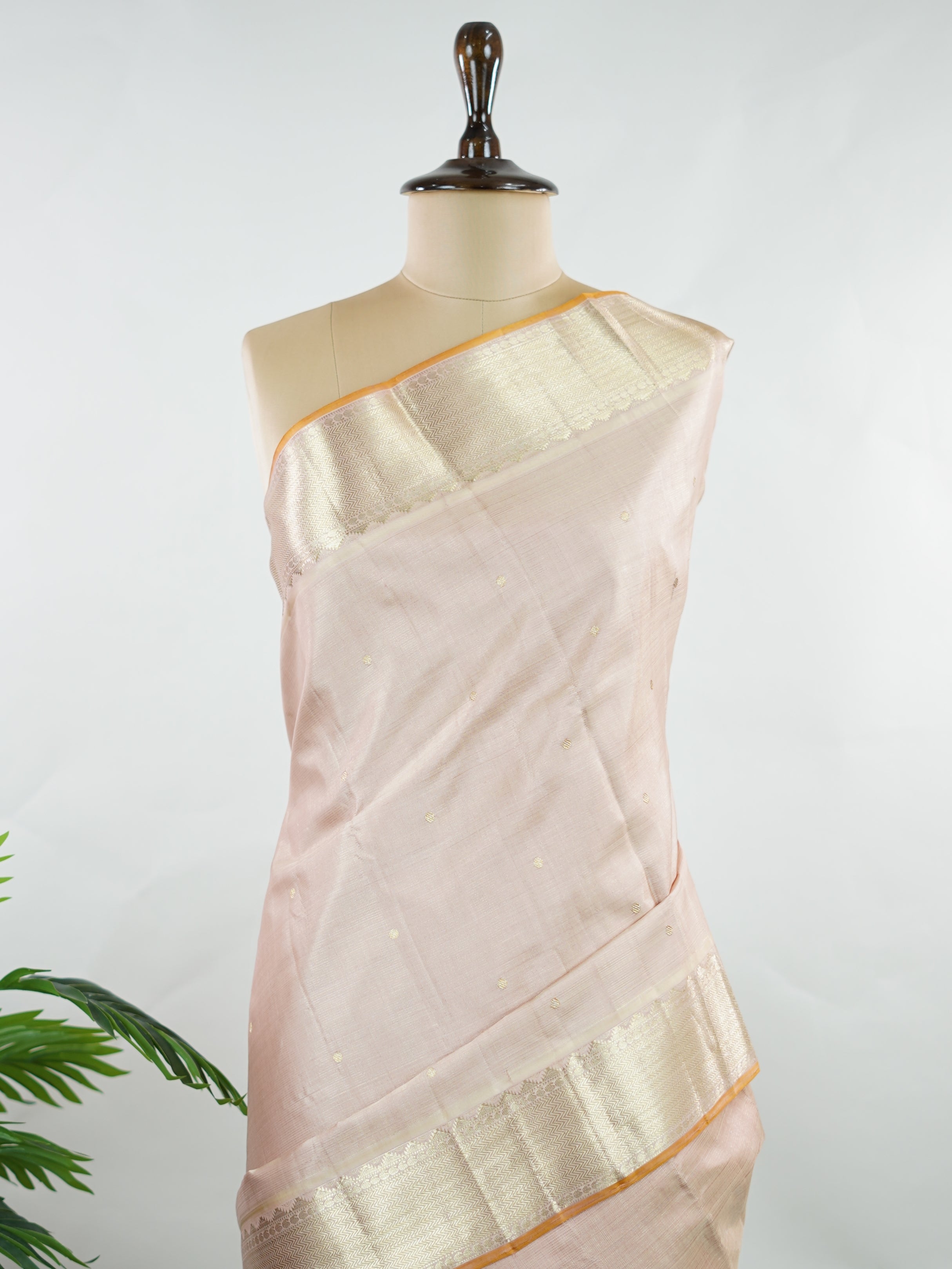 Kanchipuram Silk Understated and elegant, this cream Kanjivaram saree is woven in luxurious 100% pure silk for a soft, graceful drape. Featuring classic Vairavoosi weaving complemented by delicate buttis across the body, it reflects timeless craftsmanship with subtle richness. A refined choice for weddings, traditional gatherings, and serene festive moments. Anandalahari - Cream Pure Kanjivaram Silk Saree - Manoranjitham Weaves - Handloom Store
