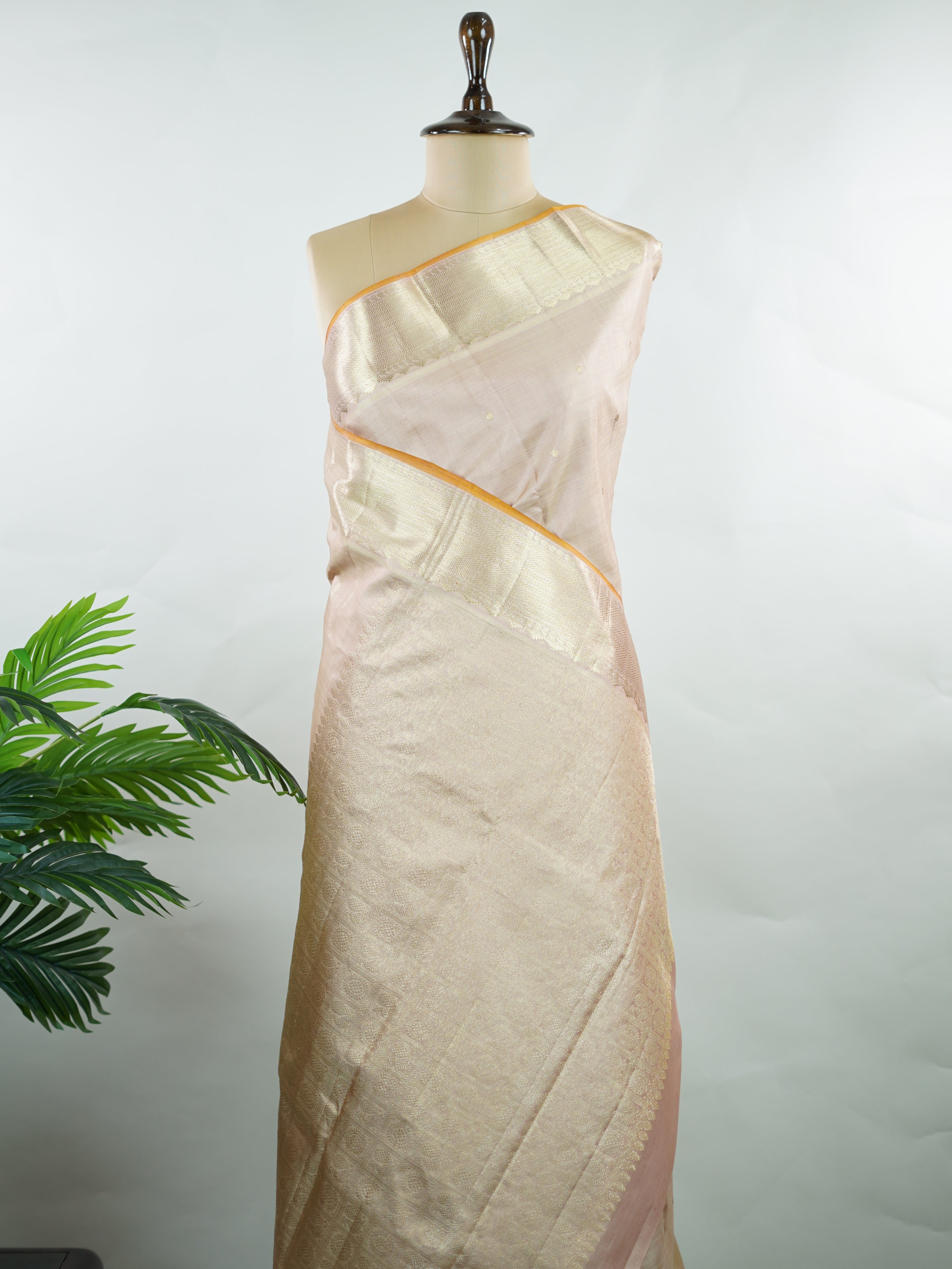 Kanchipuram Silk Understated and elegant, this cream Kanjivaram saree is woven in luxurious 100% pure silk for a soft, graceful drape. Featuring classic Vairavoosi weaving complemented by delicate buttis across the body, it reflects timeless craftsmanship with subtle richness. A refined choice for weddings, traditional gatherings, and serene festive moments. Anandalahari - Cream Pure Kanjivaram Silk Saree - Manoranjitham Weaves - Handloom Store