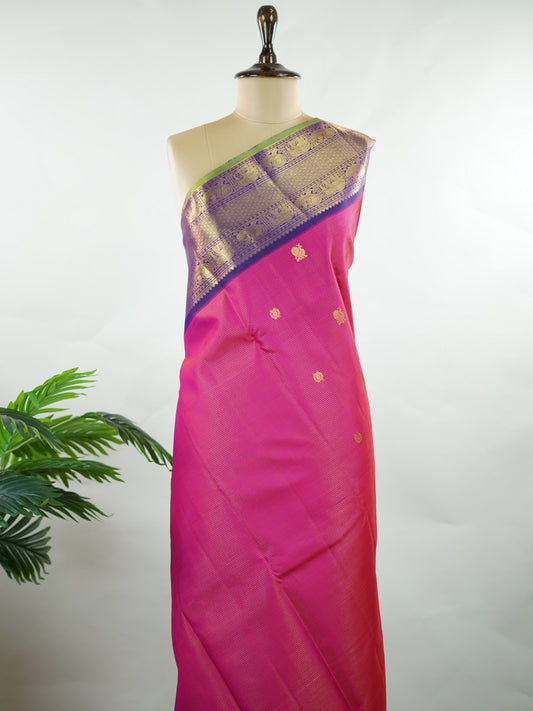 Kanchipuram Silk Graceful and striking, this pink Kanjivaram saree is woven in luxurious 100% pure silk for a rich, elegant drape. The classic Vaira Oosi weave adds refined texture to the body, while the bold blue gatti border enhances its traditional grandeur. A perfect blend of heritage craftsmanship and vibrant contrast—ideal for weddings and festive celebrations. Kamalatmika - Manoranjitham Weaves - Handloom Store