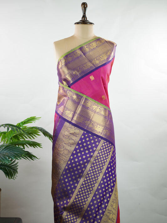 Kanchipuram Silk Graceful and striking, this pink Kanjivaram saree is woven in luxurious 100% pure silk for a rich, elegant drape. The classic Vaira Oosi weave adds refined texture to the body, while the bold blue gatti border enhances its traditional grandeur. A perfect blend of heritage craftsmanship and vibrant contrast—ideal for weddings and festive celebrations. Kamalatmika - Manoranjitham Weaves - Handloom Store