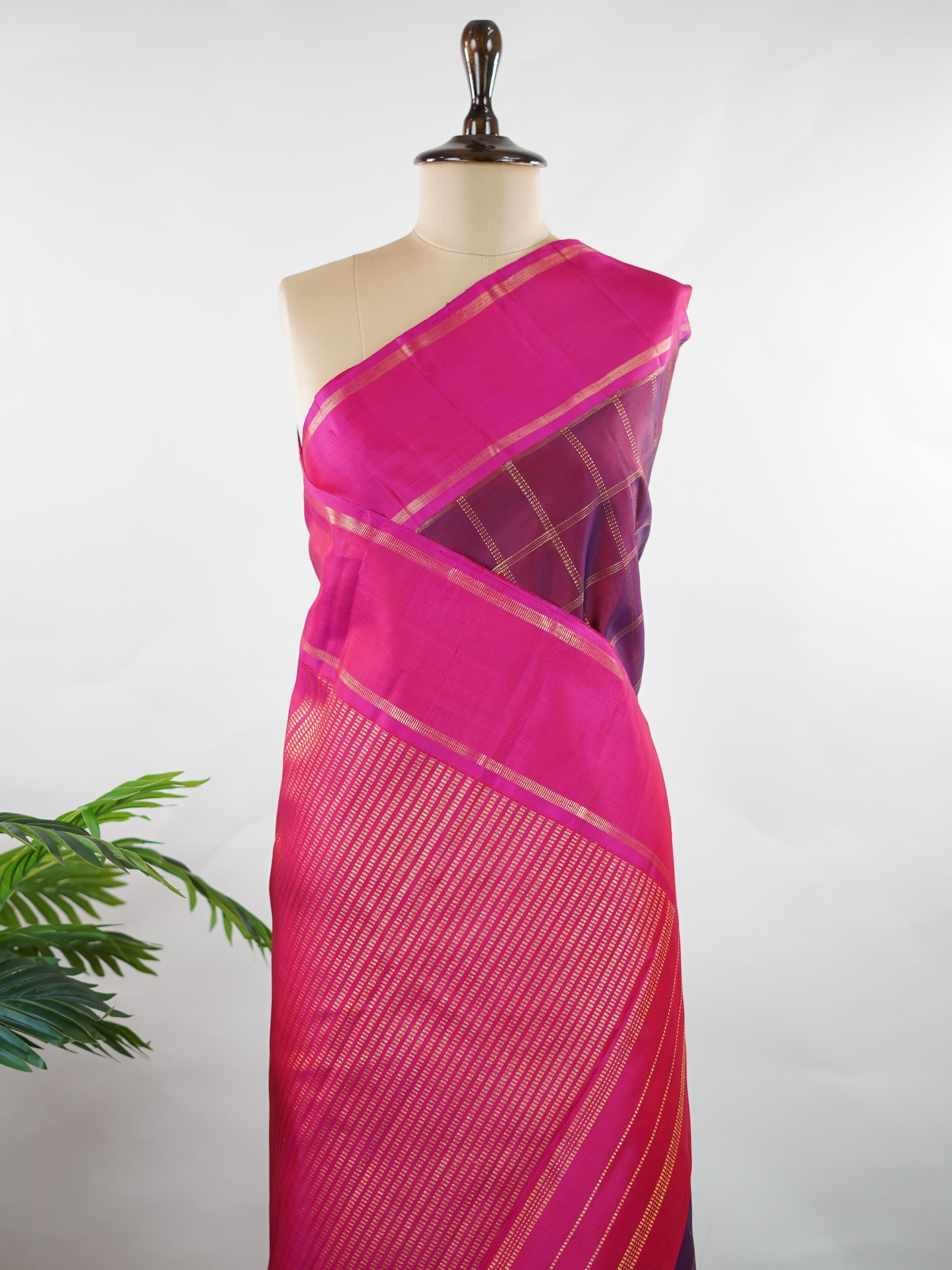 Kanchipuram Silk Rich and regal, this maroon Kanjivaram saree is crafted in luxurious 100% pure silk. The bold big checks create a striking traditional pattern, beautifully complemented by a contrasting pink gatti border. A grand and timeless choice for weddings and festive occasions. Shivaduti - Maroon Pure Kanjivaram Silk Saree | Classic Checks - Manoranjitham Weaves - Handloom Store