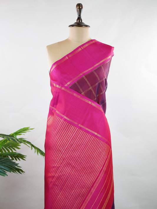 Kanchipuram Silk Rich and regal, this maroon Kanjivaram saree is crafted in luxurious 100% pure silk. The bold big checks create a striking traditional pattern, beautifully complemented by a contrasting pink gatti border. A grand and timeless choice for weddings and festive occasions. Shivaduti - Manoranjitham Weaves - Handloom Store