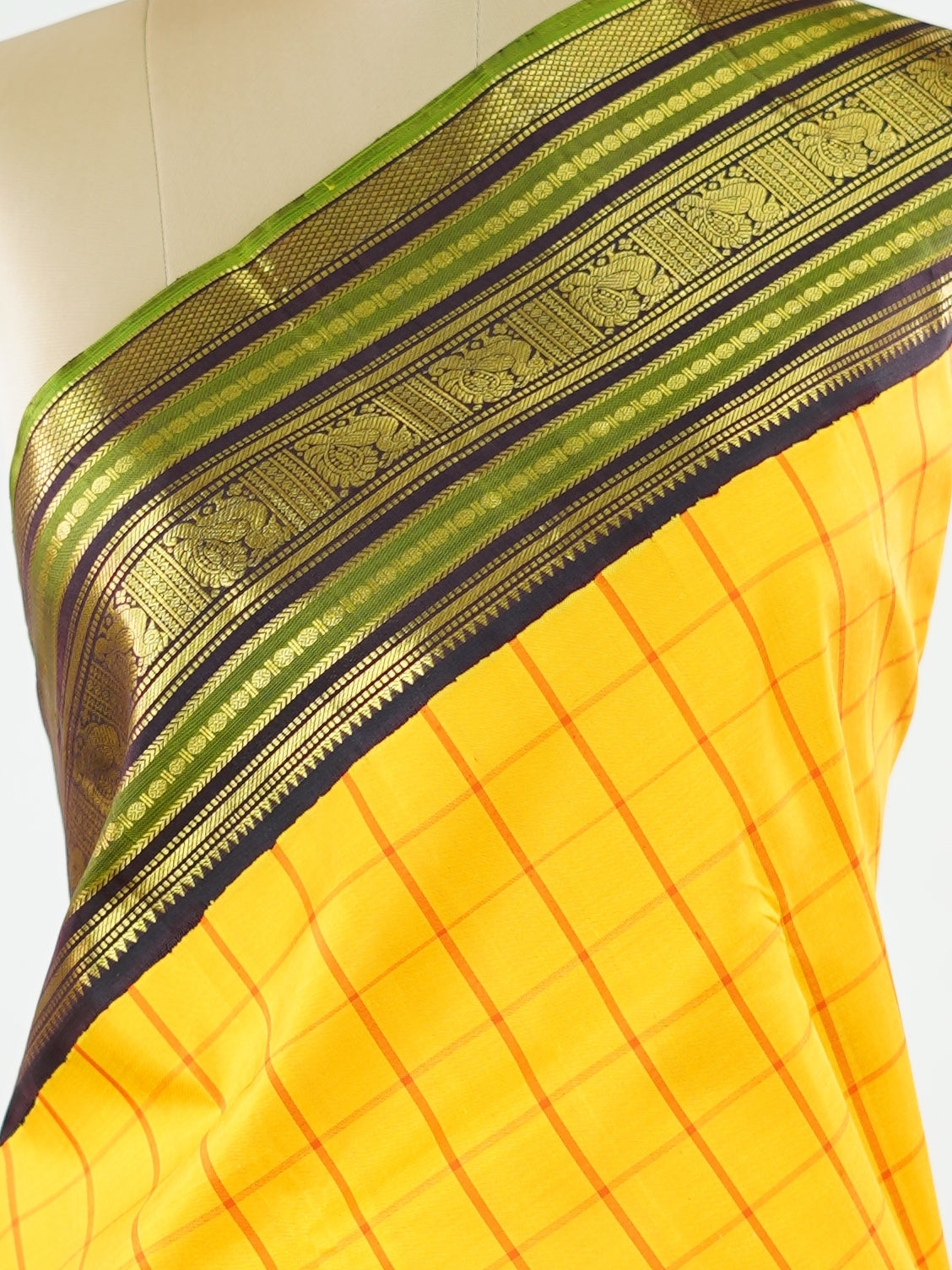 Kanchipuram Silk Bright and earthy in contrast, this yellow Kanjivaram saree features classic checks that enhance its traditional charm. The snuff-toned gatti border adds depth and definition, making it a vibrant yet elegant pick for celebrations and special gatherings Nityakalyani - Manoranjitham Weaves - Handloom Store