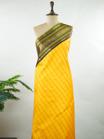 Kanchipuram Silk Bright and earthy in contrast, this yellow Kanjivaram saree features classic checks that enhance its traditional charm. The snuff-toned gatti border adds depth and definition, making it a vibrant yet elegant pick for celebrations and special gatherings Nityakalyani - Manoranjitham Weaves - Handloom Store
