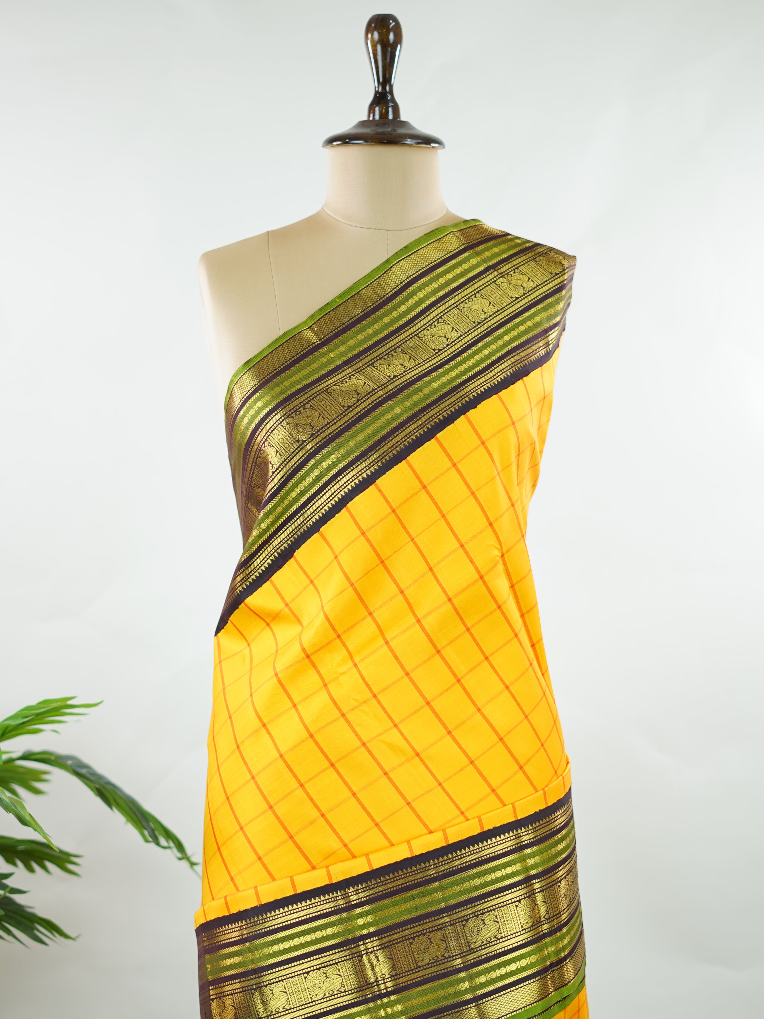 Kanchipuram Silk Bright and earthy in contrast, this yellow Kanjivaram saree features classic checks that enhance its traditional charm. The snuff-toned gatti border adds depth and definition, making it a vibrant yet elegant pick for celebrations and special gatherings Nityakalyani - Manoranjitham Weaves - Handloom Store