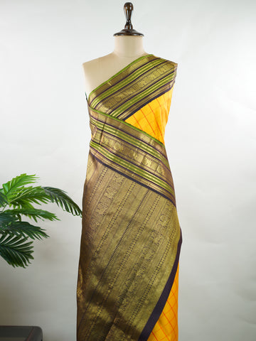 Kanchipuram Silk Bright and earthy in contrast, this yellow Kanjivaram saree features classic checks that enhance its traditional charm. The snuff-toned gatti border adds depth and definition, making it a vibrant yet elegant pick for celebrations and special gatherings Nityakalyani - Manoranjitham Weaves - Handloom Store
