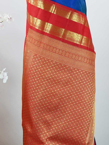 Kanchipuram Silk This exquisite Kanjivaram saree features a blue body with a striking red border, crafted from 100% pure silk.br
The body showcases a Korvai/Kuttu pattern, adorned with delicate flower motifs and peacocks flanking the border.br
Finished with elegant detailing, it beautifully highlights traditional handloom craftsmanship and timeless Kanchipuram artistry. Shivashakti - Blue Pure Kanjivaram Silk Saree - Manoranjitham Weaves - Handloom Store