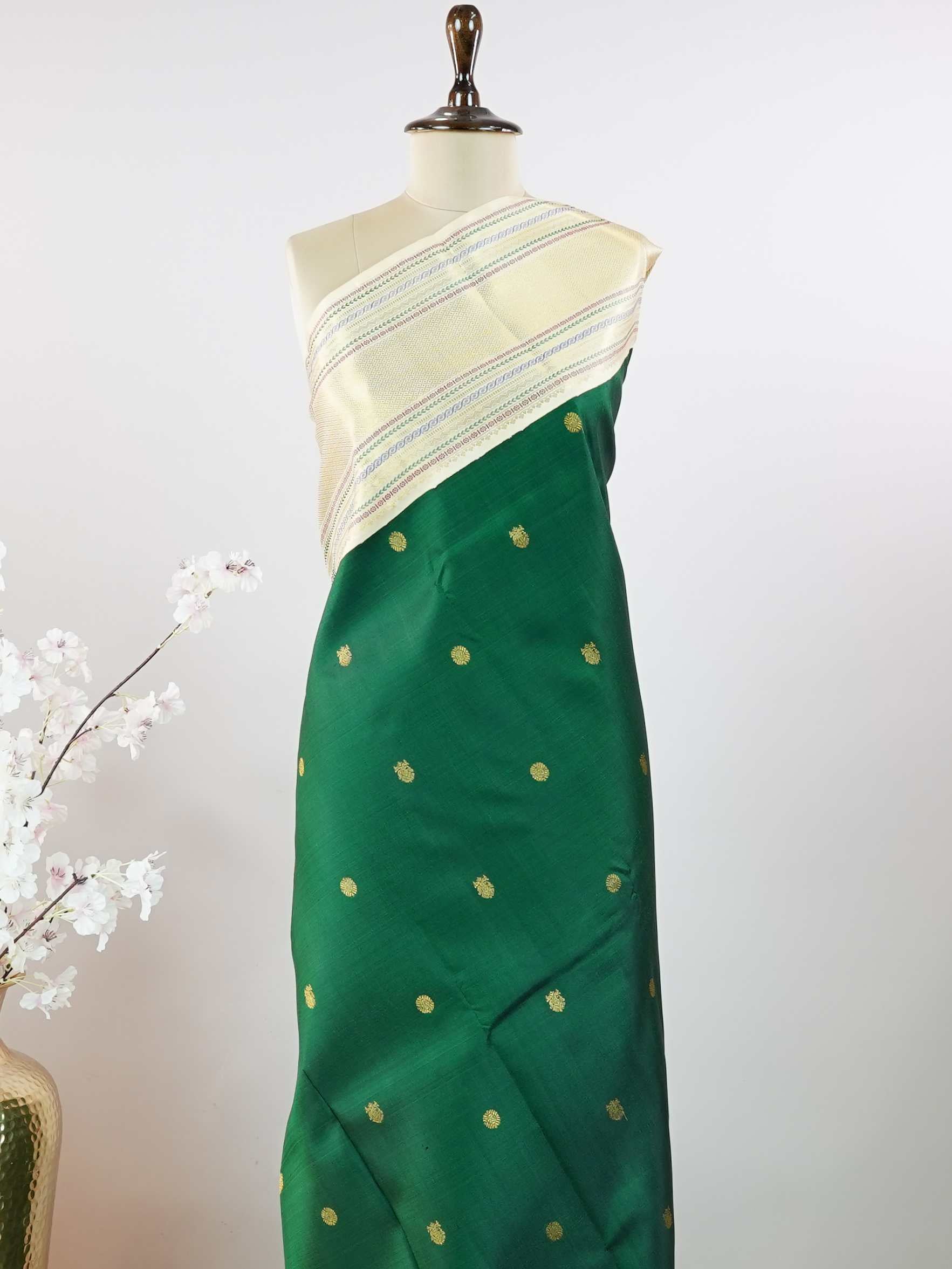 Kanchipuram Silk This beautiful Kanjivaram saree features a green body paired with a cream border, crafted from 100% pure silk.br
The body is adorned with intricate Irutali Pakshi (two-headed Ganda Beruda) motifs, showcasing traditional handloom artistry.br
Finished with elegant cream borders, it exudes timeless charm and classic Kanchipuram craftsmanship. Padmaragini - Green Pure Kanjivaram Silk Saree - Manoranjitham Weaves - Handloom Store