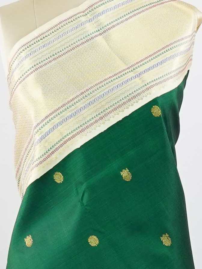 Kanchipuram Silk This beautiful Kanjivaram saree features a green body paired with a cream border, crafted from 100% pure silk.br
The body is adorned with intricate Irutali Pakshi (two-headed Ganda Beruda) motifs, showcasing traditional handloom artistry.br
Finished with elegant cream borders, it exudes timeless charm and classic Kanchipuram craftsmanship. Padmaragini - Green Pure Kanjivaram Silk Saree - Manoranjitham Weaves - Handloom Store