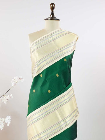 Kanchipuram Silk This beautiful Kanjivaram saree features a green body paired with a cream border, crafted from 100% pure silk.br
The body is adorned with intricate Irutali Pakshi (two-headed Ganda Beruda) motifs, showcasing traditional handloom artistry.br
Finished with elegant cream borders, it exudes timeless charm and classic Kanchipuram craftsmanship. Padmaragini - Green Pure Kanjivaram Silk Saree - Manoranjitham Weaves - Handloom Store