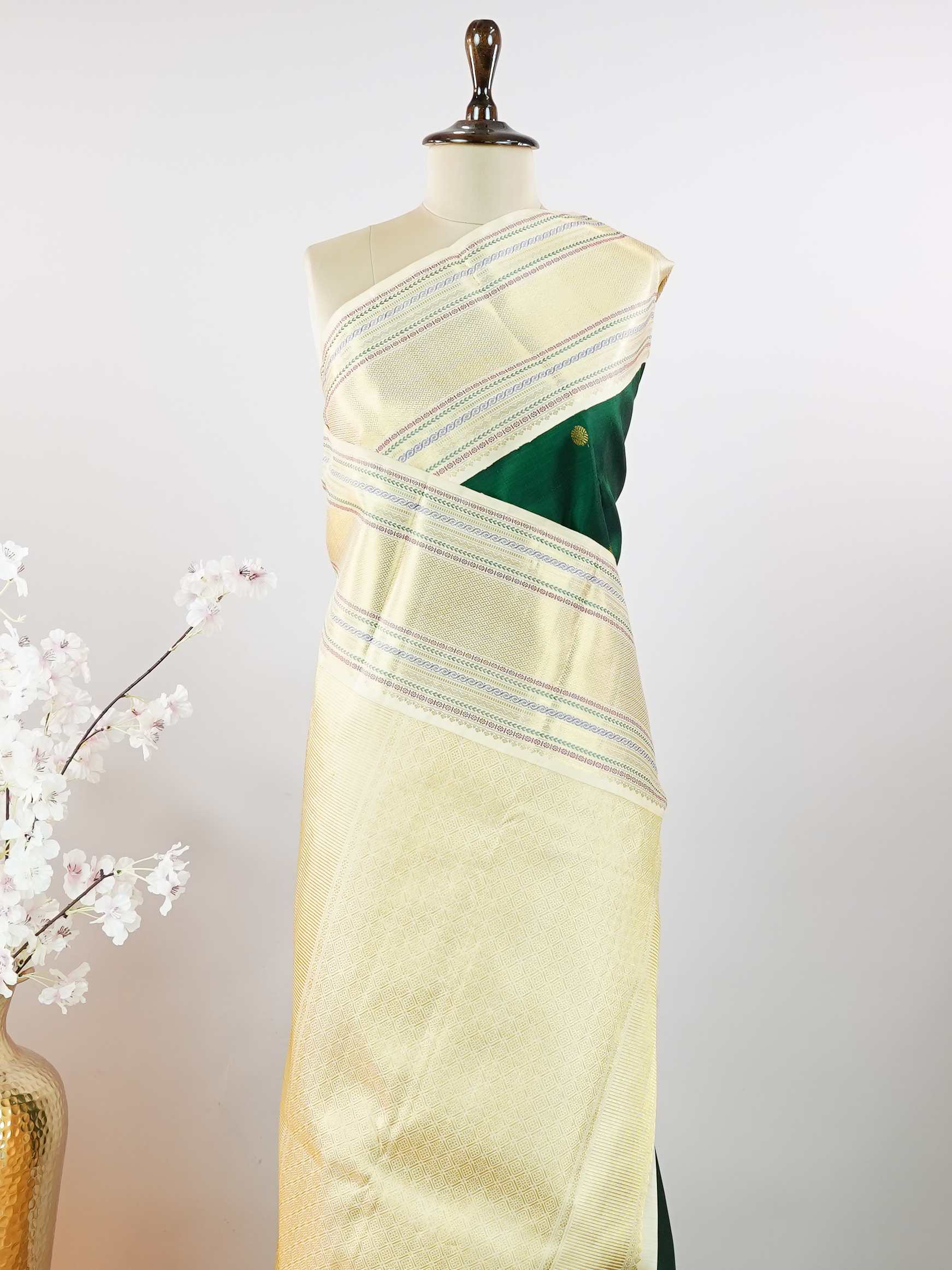 Kanchipuram Silk This beautiful Kanjivaram saree features a green body paired with a cream border, crafted from 100% pure silk.br
The body is adorned with intricate Irutali Pakshi (two-headed Ganda Beruda) motifs, showcasing traditional handloom artistry.br
Finished with elegant cream borders, it exudes timeless charm and classic Kanchipuram craftsmanship. Padmaragini - Green Pure Kanjivaram Silk Saree - Manoranjitham Weaves - Handloom Store