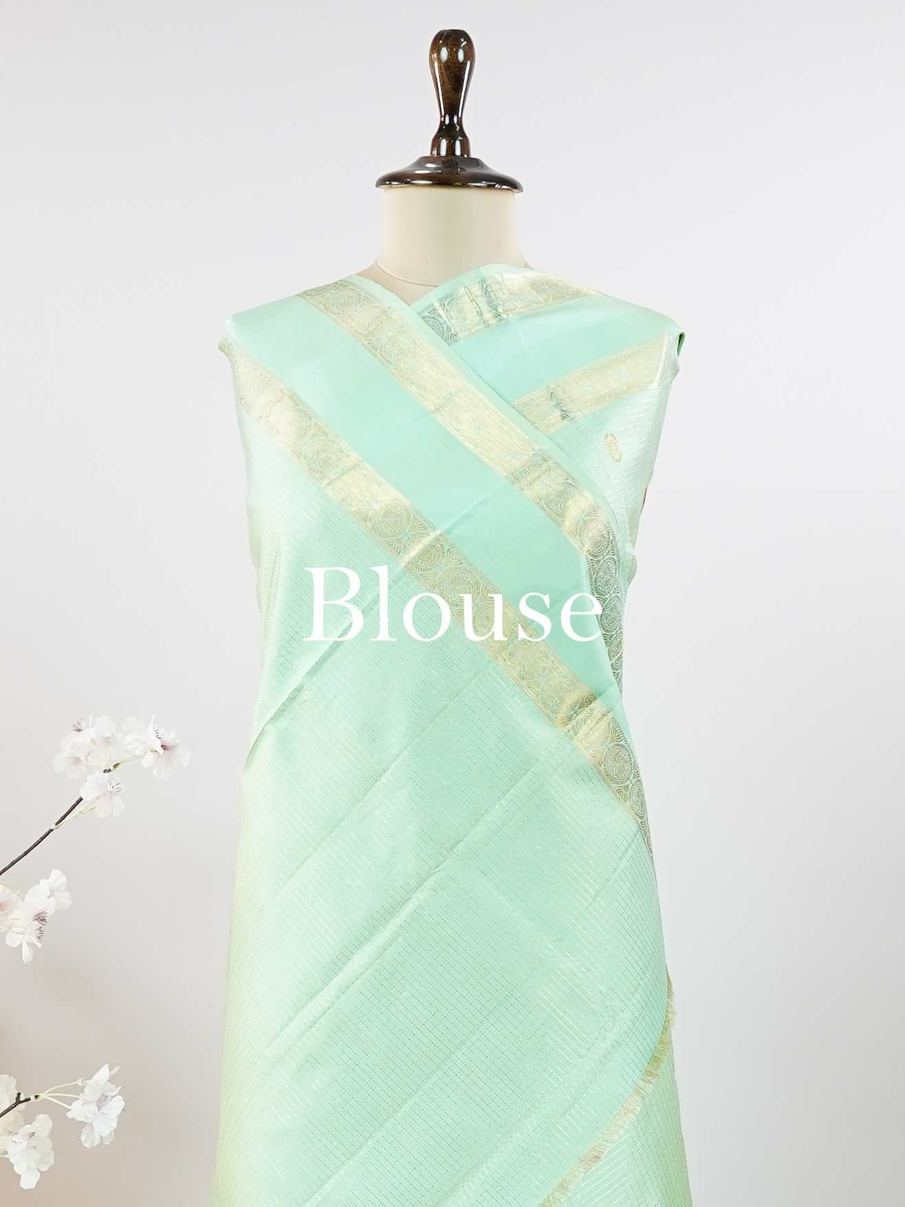 Kanchipuram Silk This elegant Kanjivaram saree in mint green is crafted from 100% pure silk for a luxurious feel.br
Featuring traditional Oosi Kattam—zari checks with buttas—on the body, it showcases exquisite handloom artistry.br
The matching mint green saree is finished with a subtle gap border, adding understated charm and elegance. Chidrupini - Mint Green Pure Kanjivaram Silk Saree - Manoranjitham Weaves - Handloom Store
